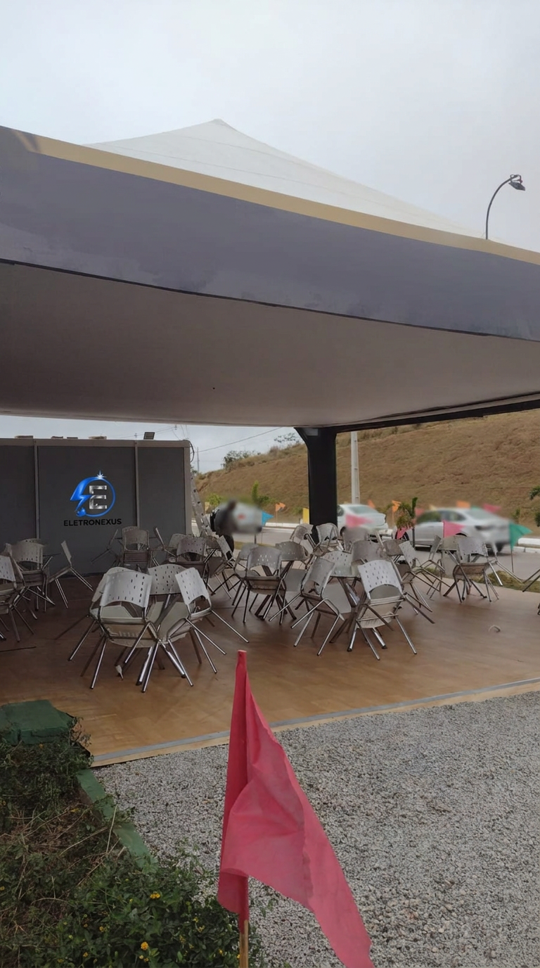 Área de mesas e cadeiras do stand com iluminação instalada